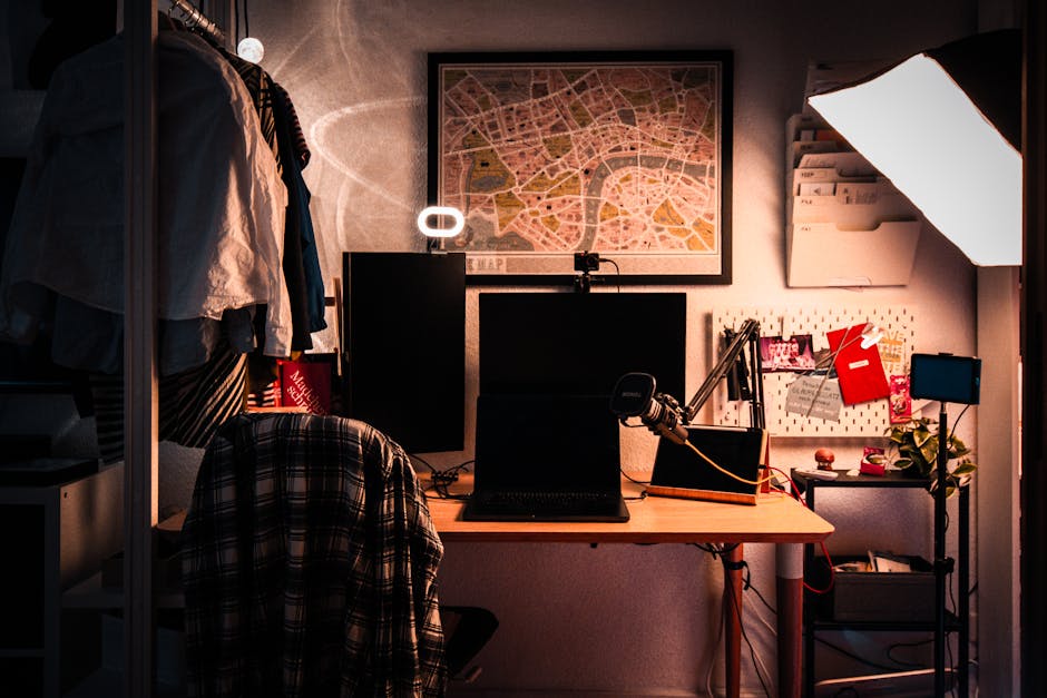 Warmly lit home office desk setup with dual monitors, cozy decor, and map wall art.