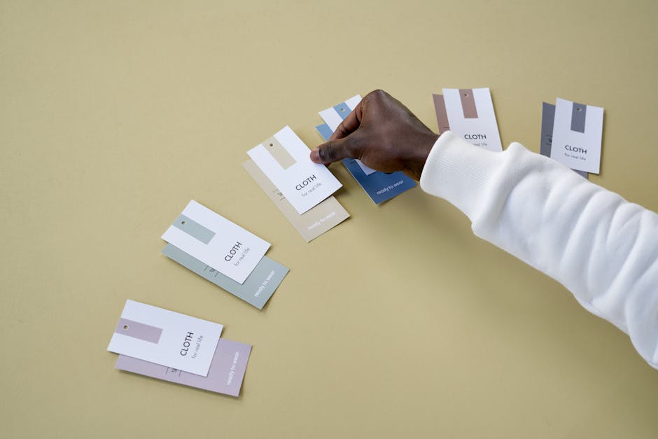 A person choosing fabric swatches, showing multiple color options on a neutral surface. Ideal for design concepts.